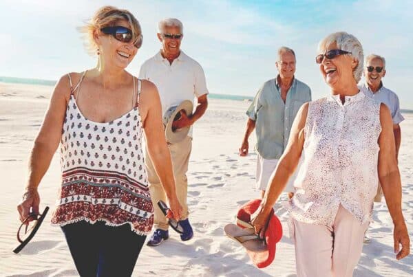A group of senior women and men walking on the beach